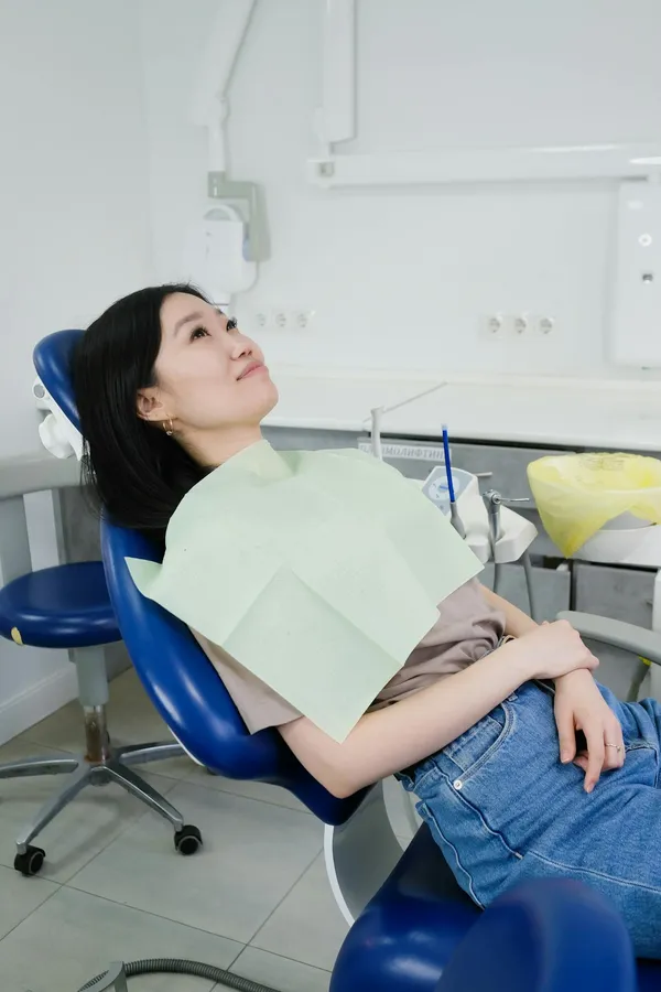 Patient relaxed and comfortable in a dental treatment chair — same-day teeth surgery is performed under local anaesthesia with sedation available